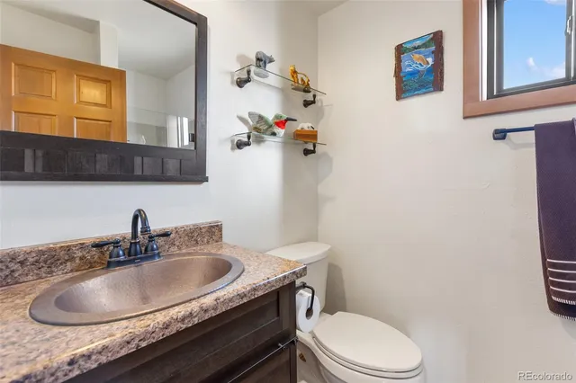 a bathroom with a sink a toilet and mirror