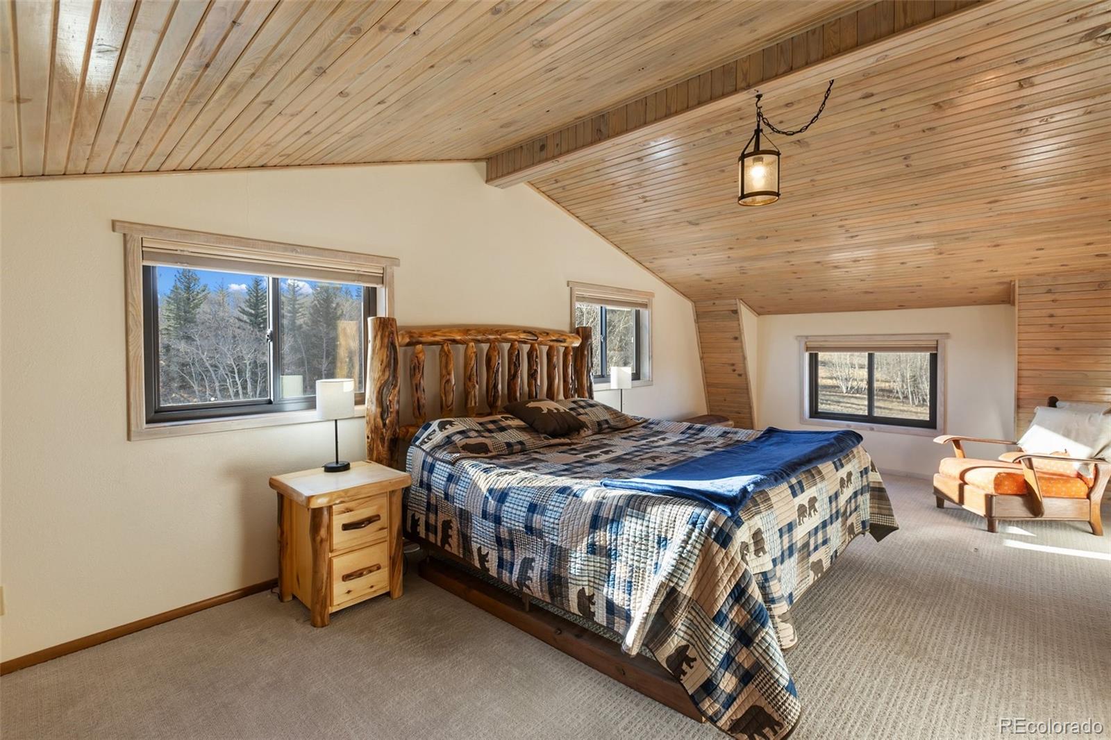2387 Buffalo Ridge Road Como, CO 80456 - Photo 23 of 50 a bedroom with a bed next to a window and a chandelier