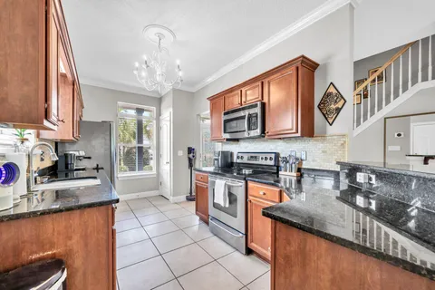 a kitchen with stainless steel appliances granite countertop a sink stove and cabinets