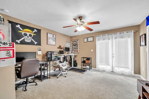 a view of a workspace with furniture and a window