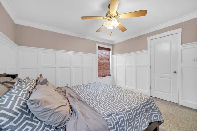 a bedroom with a large bed and a ceiling fan