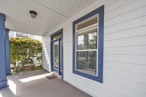 a view of a porch with furniture and floor to ceiling window
