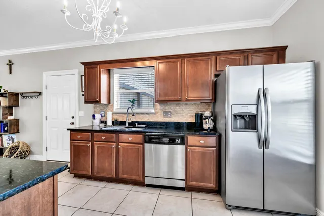 a kitchen with stainless steel appliances granite countertop a refrigerator a sink dishwasher a stove with wooden cabinets and floor