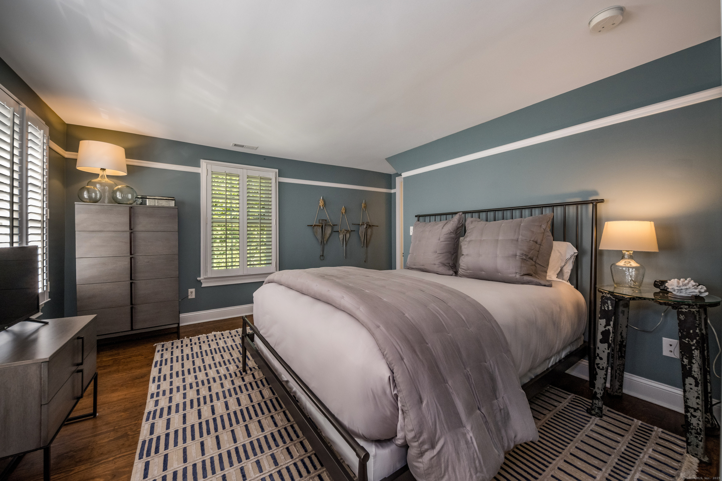 137 Liberty Street Madison, CT 06443 - Photo 17 of 40 a bedroom with a bed and wooden floor