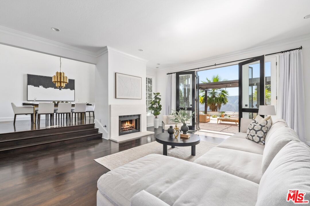 2241 Canyonback Road Los Angeles, CA 90049 - Photo 3 of 26 a living room with fireplace furniture and a floor to ceiling window