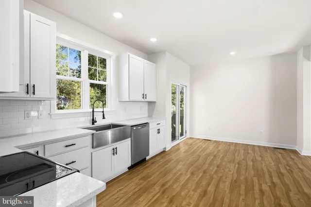 a kitchen with a sink a window and cabinets