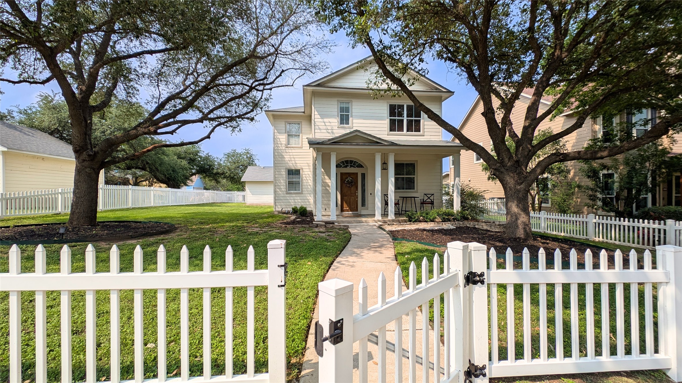 Two-story residence with a covered front porch and a wood-finish entry door