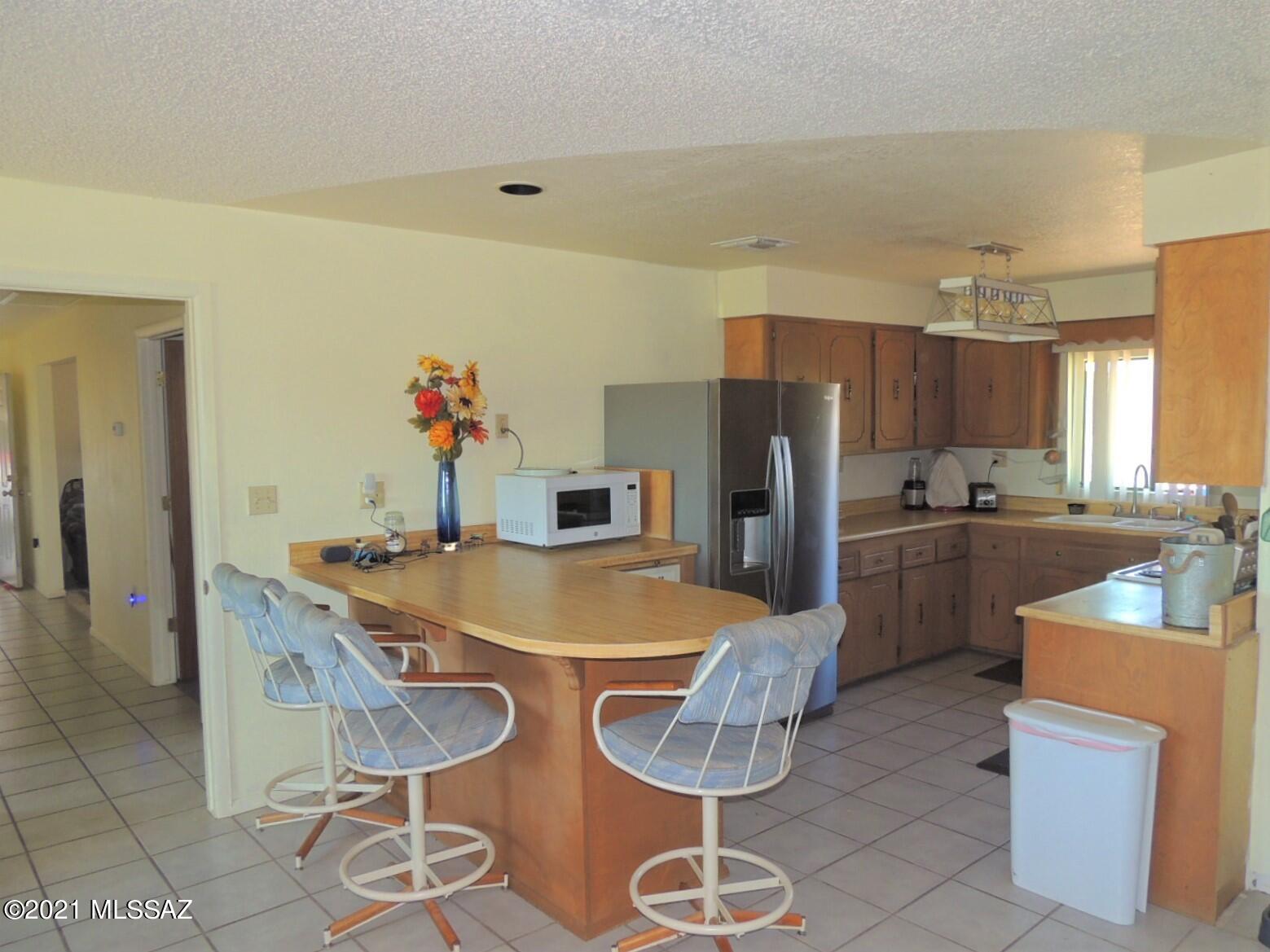 3454 East Fawn Ranch Road Pearce, AZ 85625 - Photo 18 of 49 a kitchen with stainless steel appliances granite countertop a sink refrigerator and cabinets