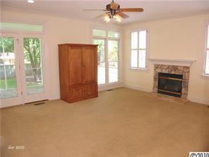 448 South Sharon Amity Road Charlotte, NC 28211 - Photo 5 of 16 an empty room with windows fireplace and a chandelier fan