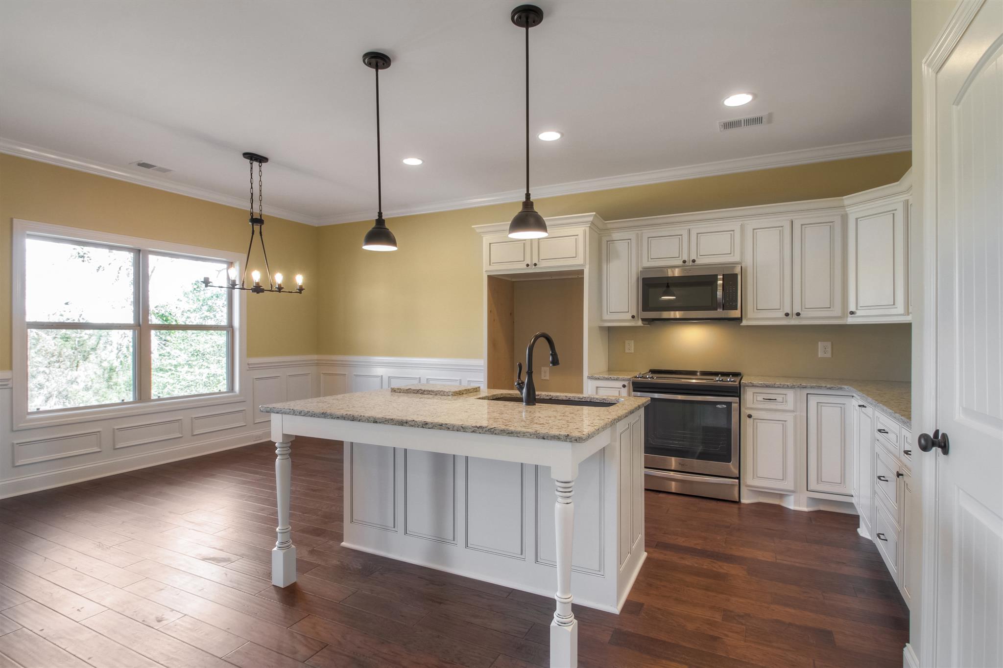 1 Bates Road Lebanon, TN 37087 - Photo 4 of 15 a kitchen with kitchen island granite countertop a stove a sink a center island a refrigerator and a wooden floor