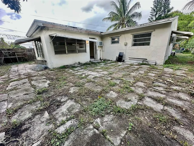 a view of a house with backyard and a tree