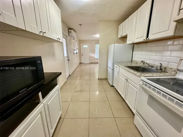 a kitchen with granite countertop a stove and a sink
