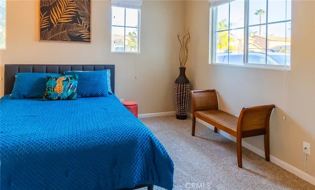 a blue bed sitting in a bedroom next to a window