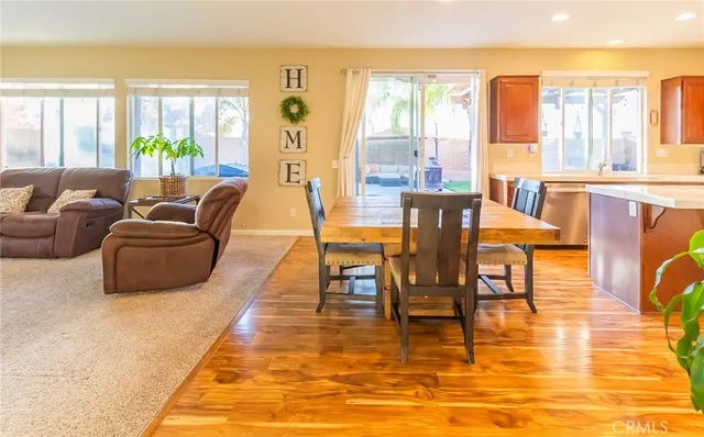 a view of a dining room with furniture a chandelier and wooden floor