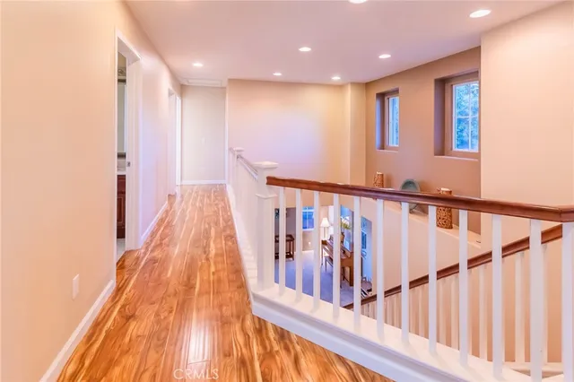 a view of a hallway with wooden floor and staircase