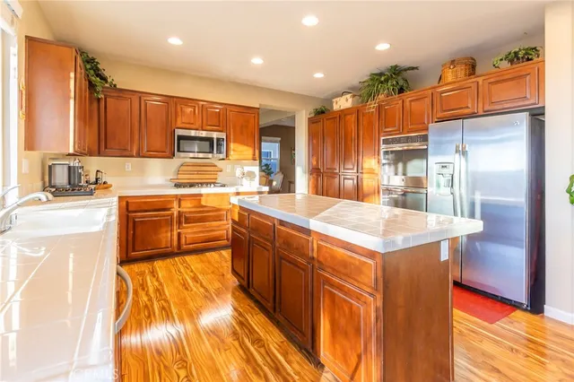 a kitchen with stainless steel appliances granite countertop a sink and a refrigerator