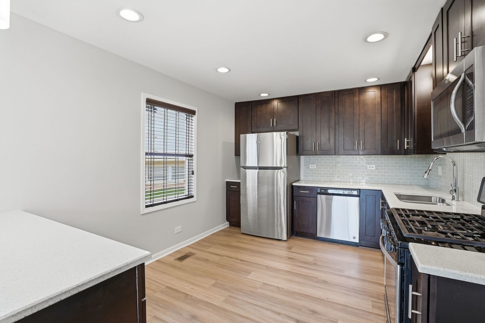 221 Davis Lane Bolingbrook, IL 60440 - Photo 5 of 24 a kitchen with refrigerator cabinets and wooden floor
