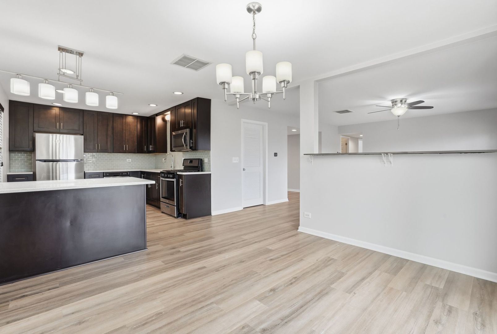 221 Davis Lane Bolingbrook, IL 60440 - Photo 8 of 24 a kitchen with stainless steel appliances granite countertop a refrigerator a sink dishwasher a stove and a dining table with wooden floor