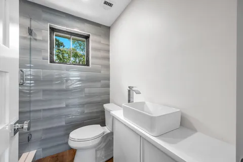 a bathroom with a toilet sink and mirror
