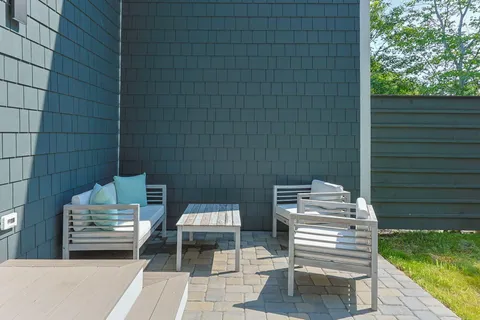 a view of a patio with table and chairs with wooden floor and fence