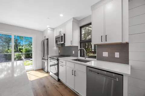 a kitchen with stainless steel appliances granite countertop a sink stove and refrigerator