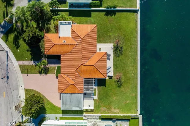 a view of a swimming pool with lawn chairs and potted plants