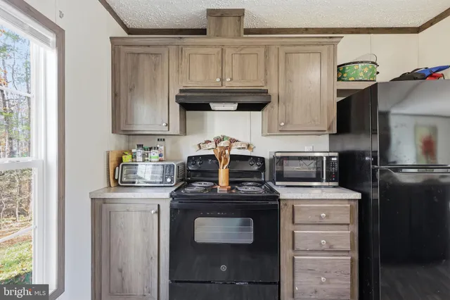 a kitchen with stainless steel appliances granite countertop a stove a refrigerator and a cabinets