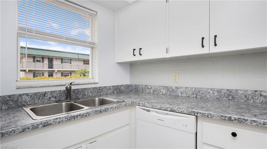 600 Valley Stream Drive, Unit C1 Naples, FL 34113 - Photo 11 of 44 Kitchen featuring dishwasher, white cabinetry, backsplash, and light countertops
