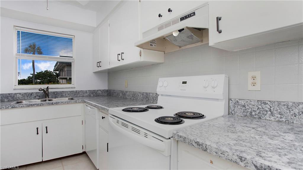 600 Valley Stream Drive, Unit C1 Naples, FL 34113 - Photo 13 of 44 Kitchen featuring white appliances, under cabinet range hood, white cabinetry