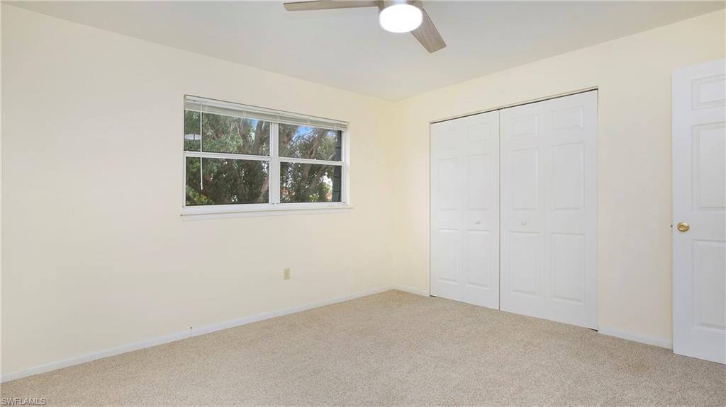 600 Valley Stream Drive, Unit C1 Naples, FL 34113 - Photo 19 of 44 Primary bedroom featuring carpet floors, a closet, and a ceiling fan