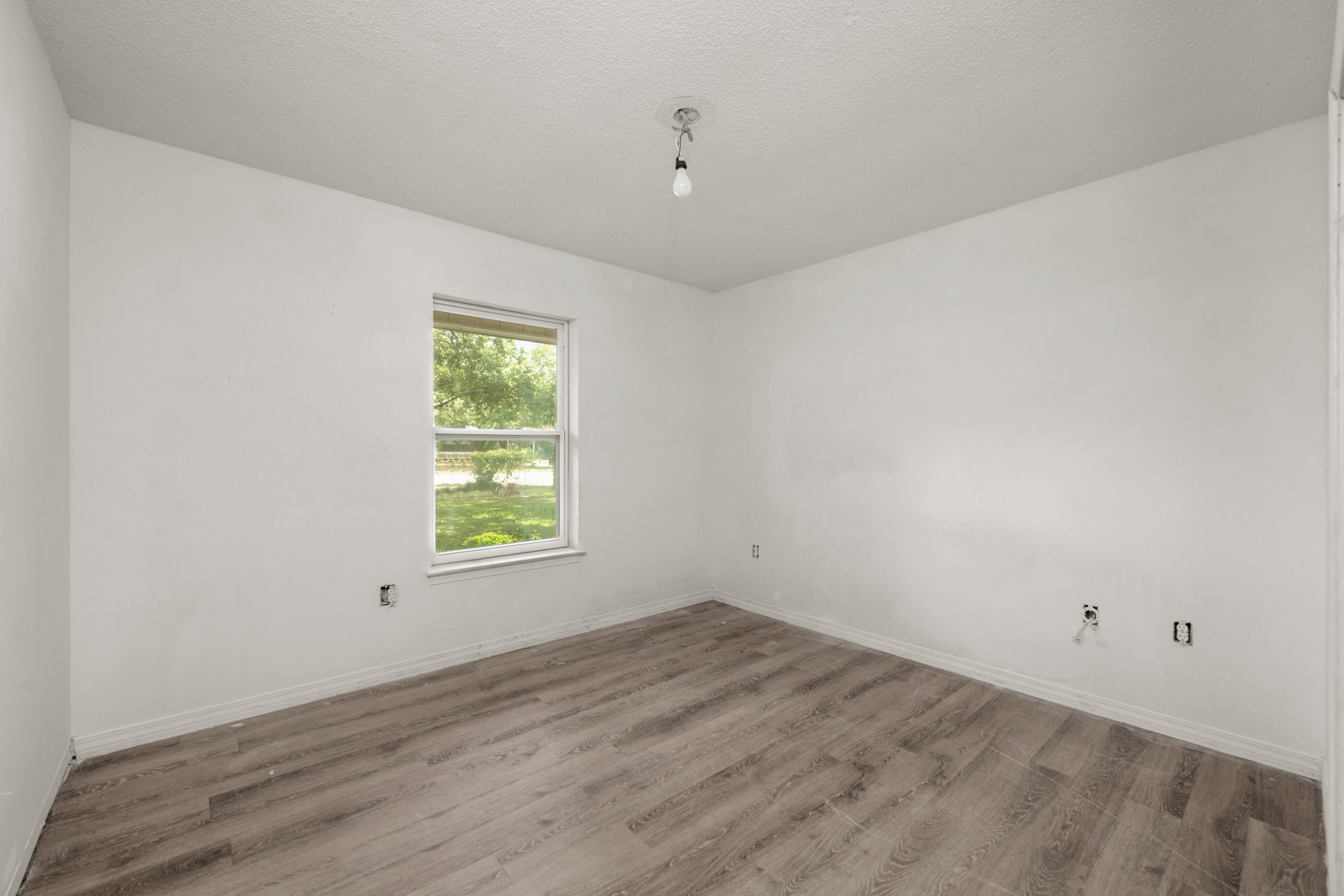 8156 4th Street Navarre, FL 32566 - Photo 11 of 23 wooden floor in an empty room with a window