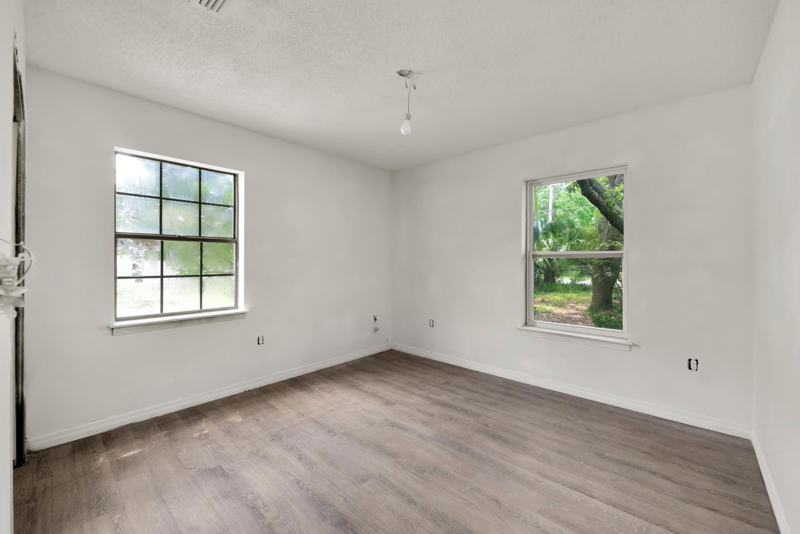 8156 4th Street Navarre, FL 32566 - Photo 12 of 23 an empty room with wooden floor and windows