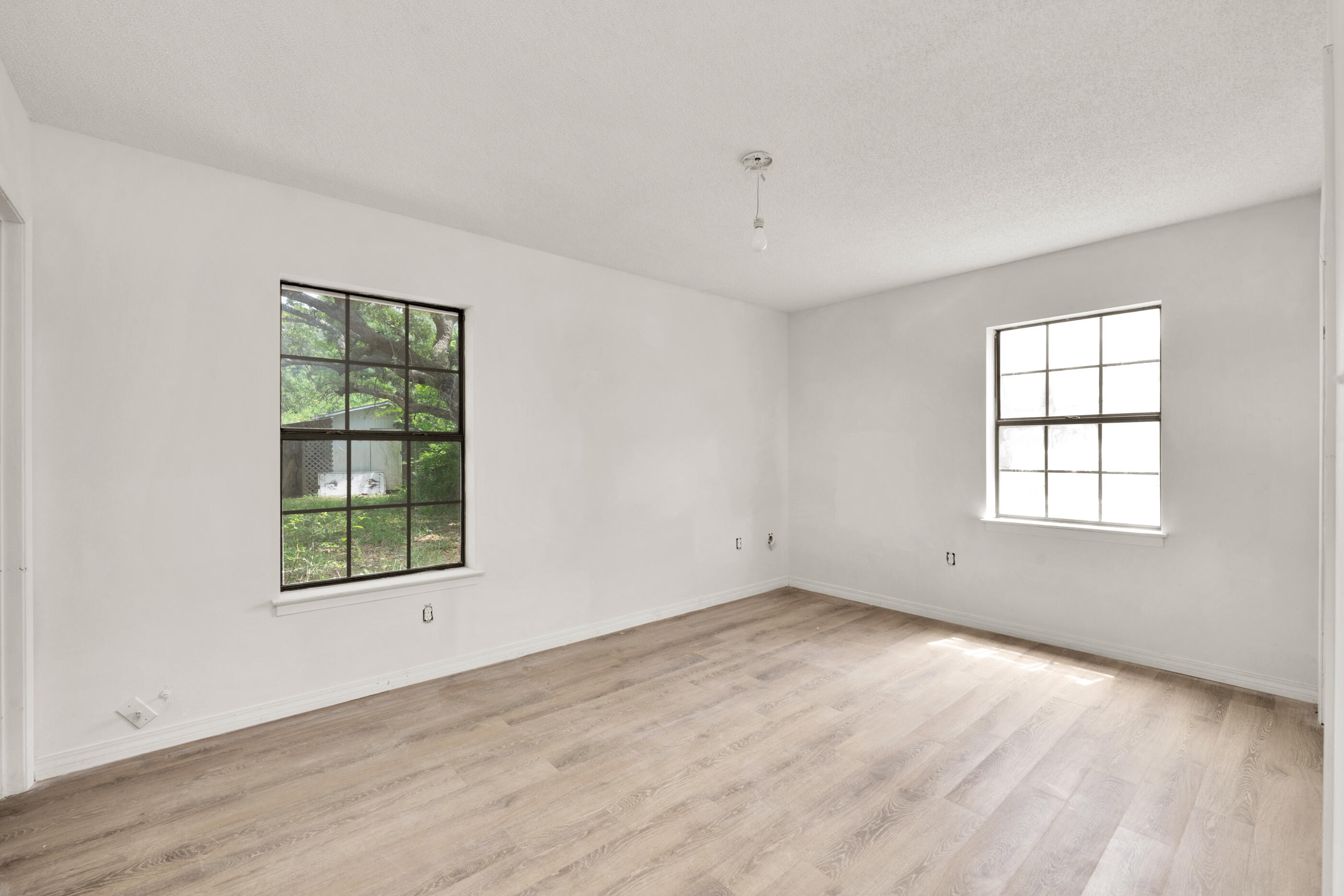8156 4th Street Navarre, FL 32566 - Photo 13 of 23 an empty room with wooden floor and windows