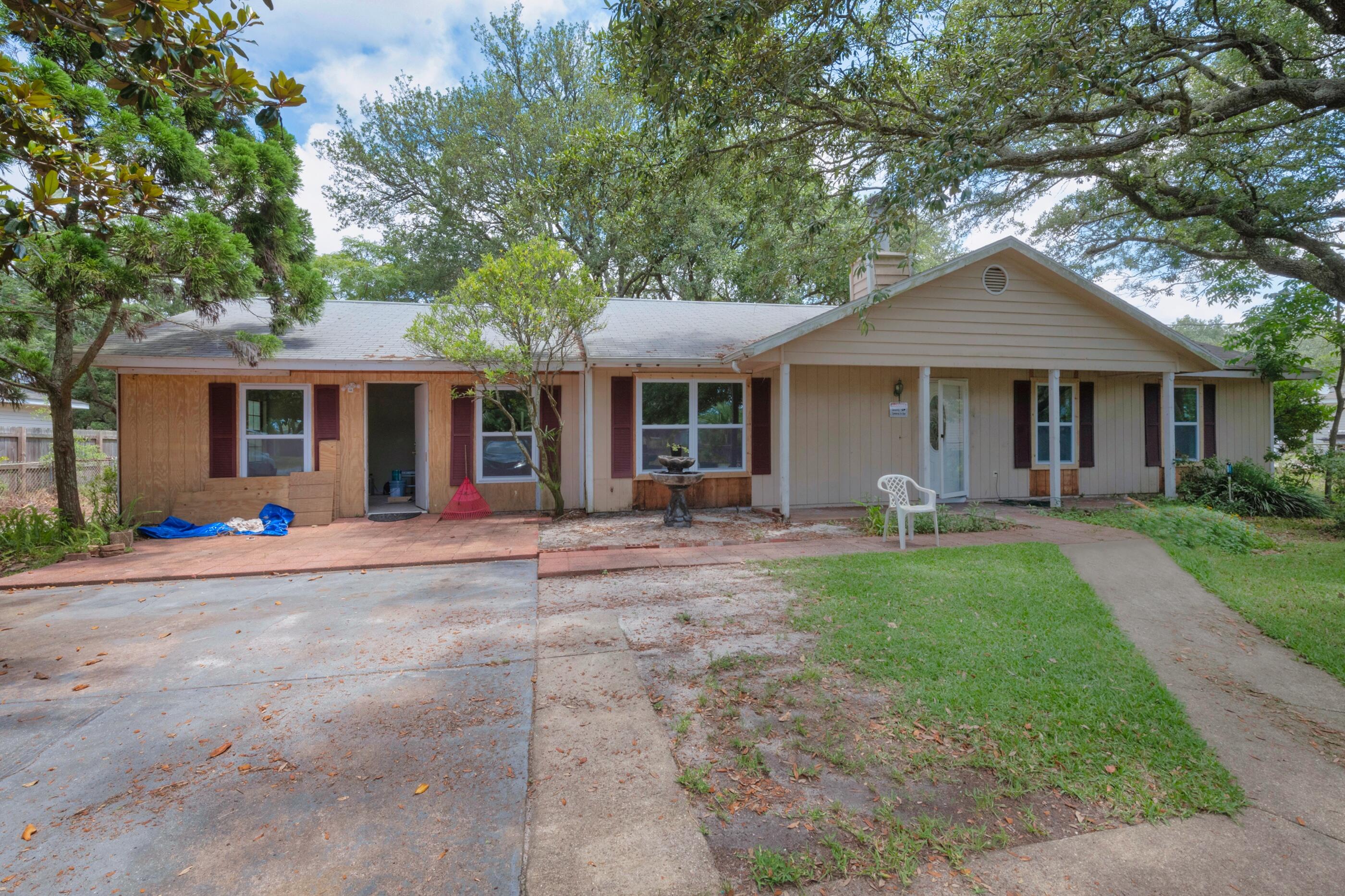 8156 4th Street Navarre, FL 32566 - Photo 2 of 23 a front view of a house with yard and green space