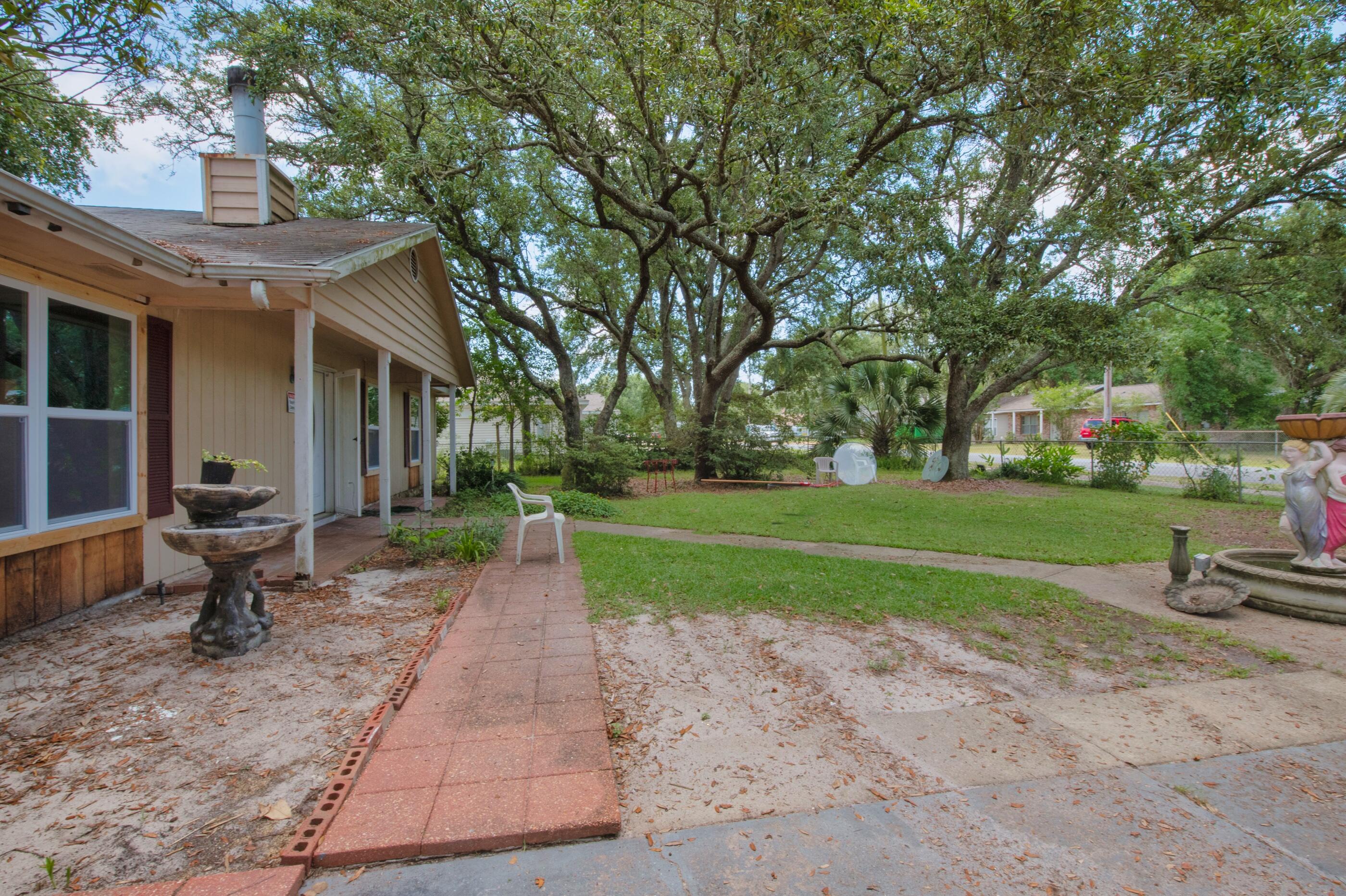 8156 4th Street Navarre, FL 32566 - Photo 3 of 23 a view of a house with backyard and garden