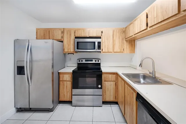 a kitchen with granite countertop a refrigerator and a sink