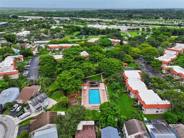 an aerial view of residential houses with outdoor space and trees