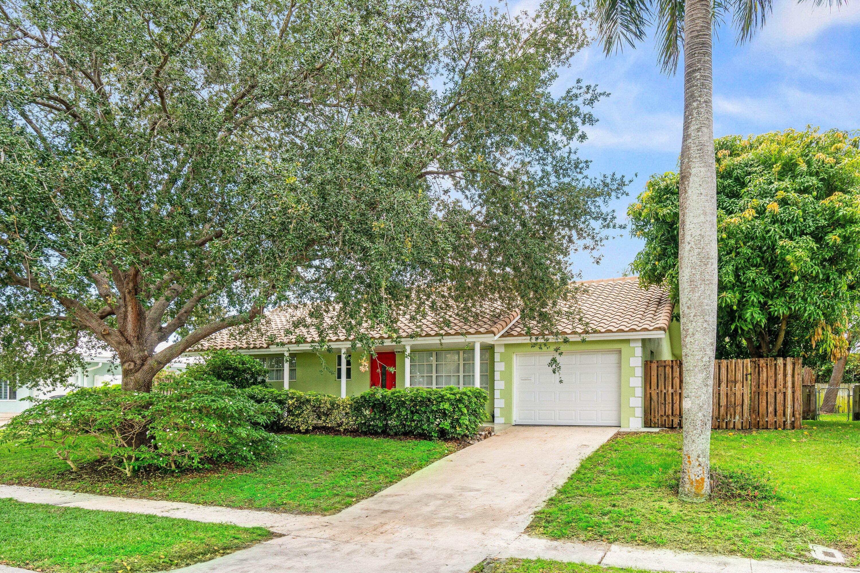 1290 Southwest 8th Street Boca Raton, FL 33486 - Photo 28 of 29 a front view of a house with a yard and trees