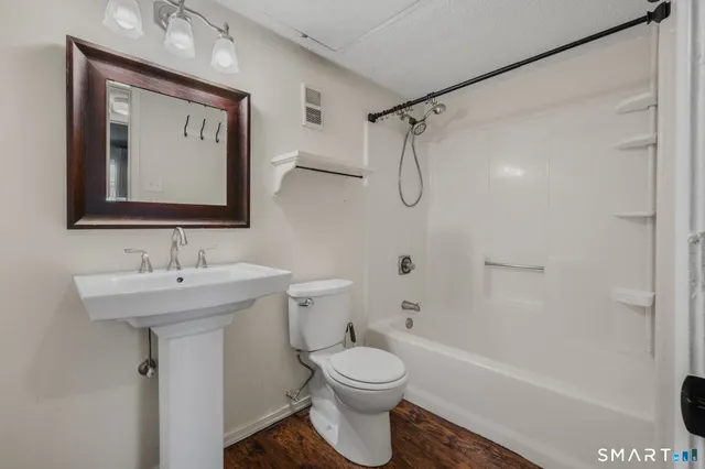 a bathroom with a toilet sink and mirror