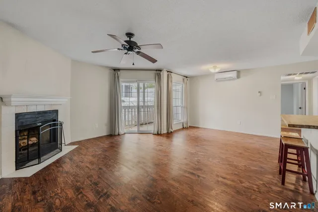 a view of empty room with wooden floor and fireplace