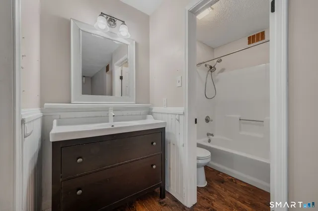 a bathroom with a sink a toilet and shower