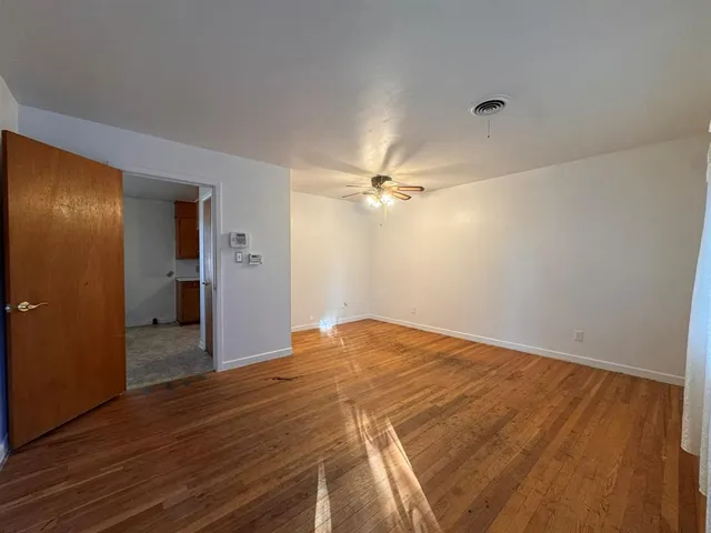a view of empty room with wooden floor