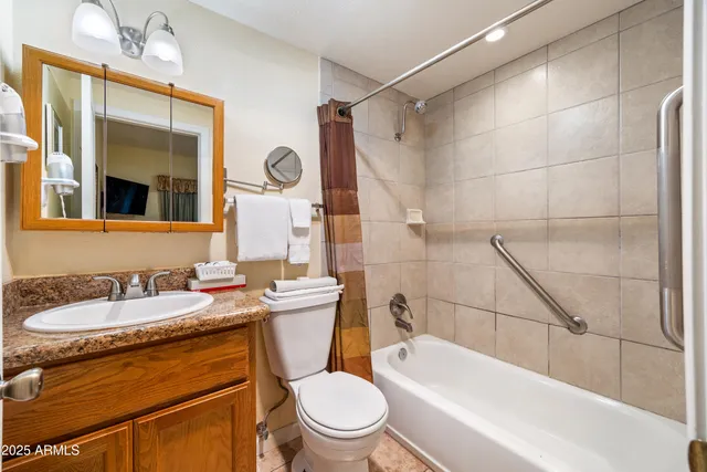 a bathroom with a sink a toilet a mirror a vanity and bathtub