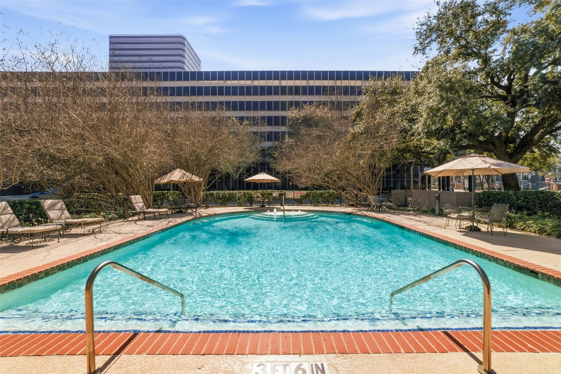 5050 Ambassador Way, Unit 309 Houston, TX 77056 - Photo 14 of 42 a view of a swimming pool with a patio and a yard