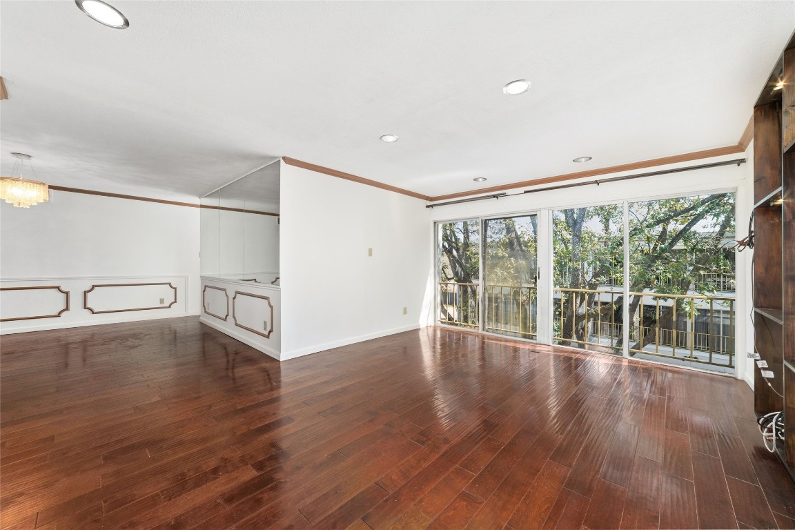 5050 Ambassador Way, Unit 309 Houston, TX 77056 - Photo 21 of 42 a view of an empty room with wooden floor and a window