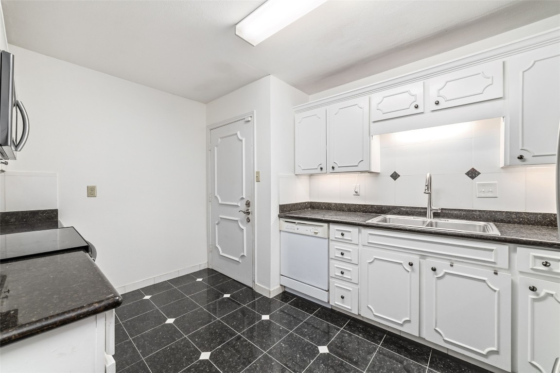 5050 Ambassador Way, Unit 309 Houston, TX 77056 - Photo 25 of 42 a kitchen with granite countertop white cabinets and white appliances