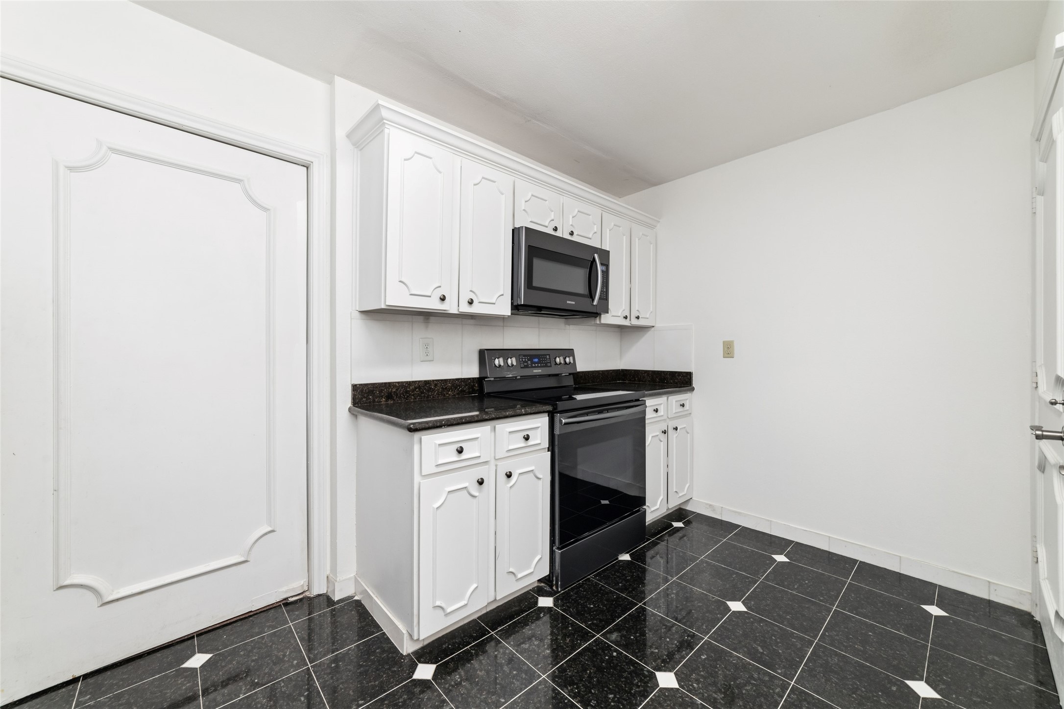 5050 Ambassador Way, Unit 309 Houston, TX 77056 - Photo 26 of 42 a kitchen with granite countertop a stove and a microwave