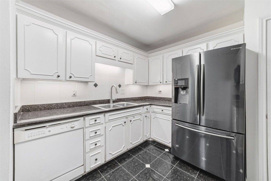 5050 Ambassador Way, Unit 309 Houston, TX 77056 - Photo 27 of 42 a kitchen with stainless steel appliances granite countertop a refrigerator sink and cabinets