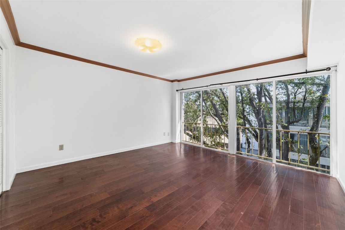 5050 Ambassador Way, Unit 309 Houston, TX 77056 - Photo 34 of 42 a view of an empty room with wooden floor and a window