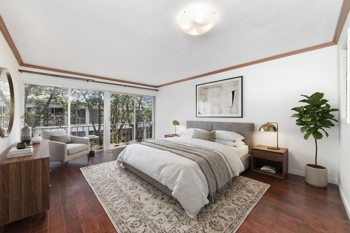 5050 Ambassador Way, Unit 309 Houston, TX 77056 - Photo 6 of 42 a bedroom with a large bed and a large window with wooden floor
